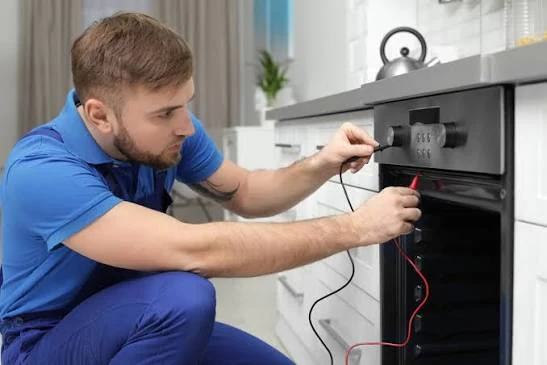 Technician testing an oven with electrical diagnostic probes